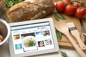 Online cooking concept. Digital tablet in a kitchen with food an
